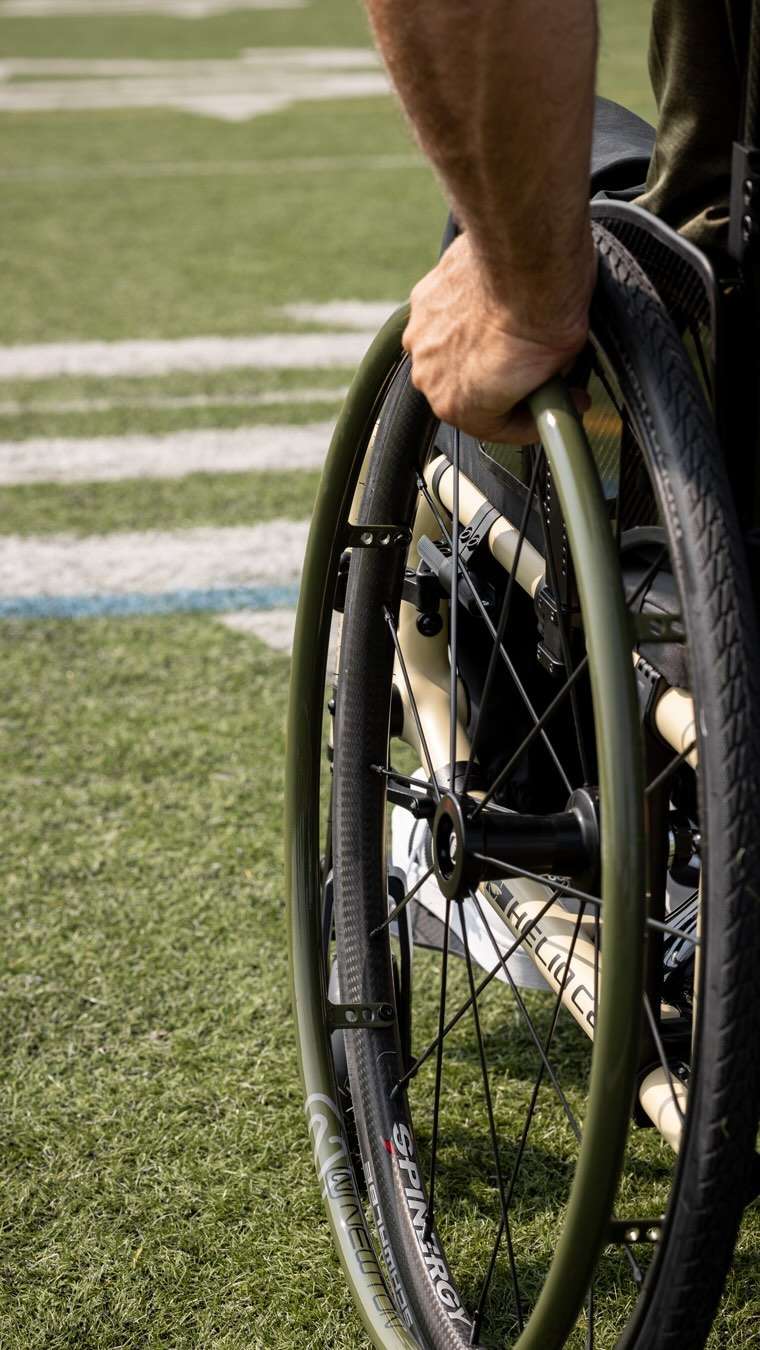 Image of a man utilizing his Newton AirGrip Handrims - Pneumatic handrims for wheelchairs, featuring an air-filled core for improved grip and comfort.