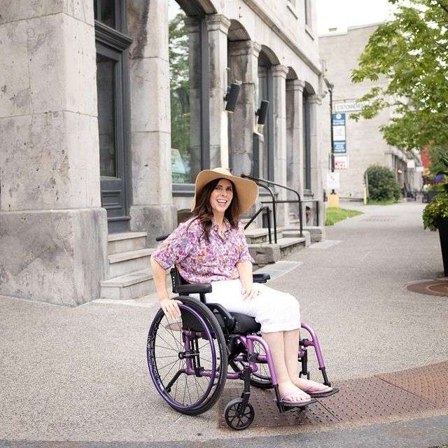 Image of a woman utilizing her Newton AirGrip Handrims - Pneumatic handrims for wheelchairs, featuring an air-filled core for improved grip and comfort.