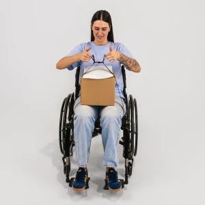 Image of a woman using the LapStacker Flex Manual Rigid Wheelchair Table - Portable, lightweight wheelchair table with adjustable height and tilt, designed for increased independence and productivity.