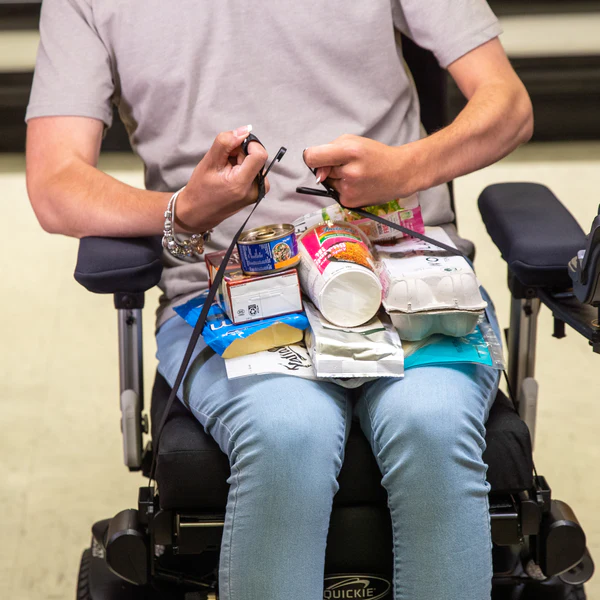 Close up image of a woman using the LapStacker XD for Quickie Wheelchairs - Adjustable, anti-slip lap tray designed for use with Quickie wheelchairs, promoting comfort and stability during daily activities.