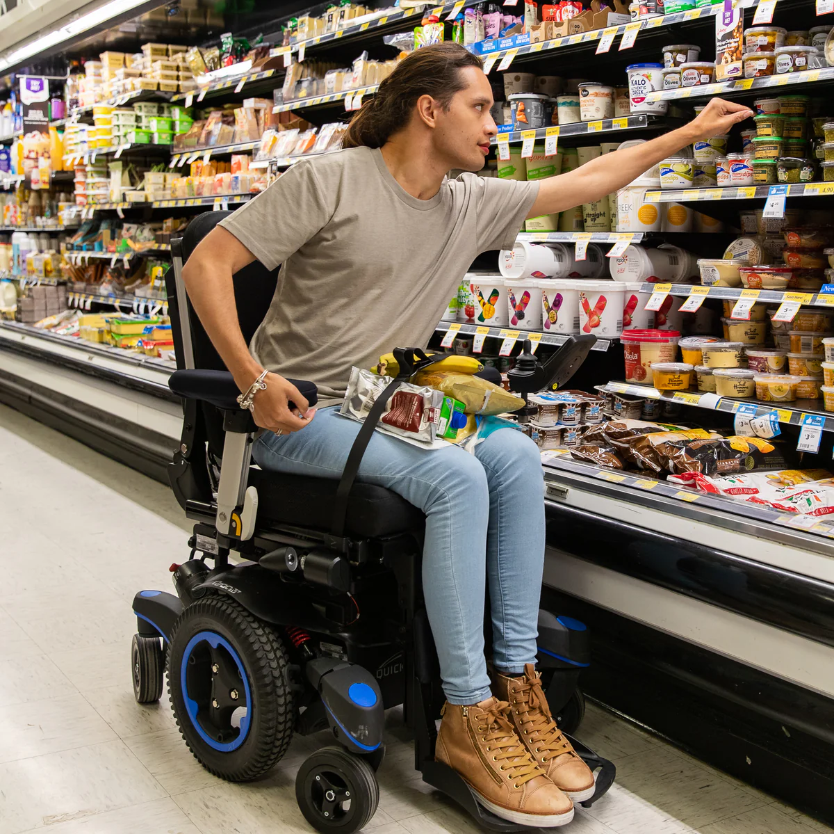 Close up image of a man shopping with the LapStacker XD for Quickie Wheelchairs - Adjustable, anti-slip lap tray designed for use with Quickie wheelchairs, promoting comfort and stability during daily activities.