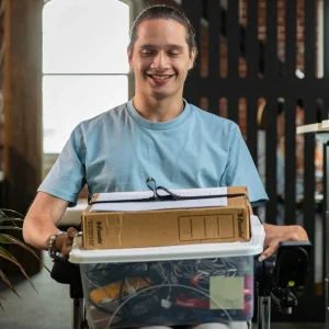 Image of a man using the LapStacker XD for Quantum Wheelchair - Portable, folding wheelchair table designed for use with Quantum Power wheelchairs, offering a stable and adjustable workspace for various activities.