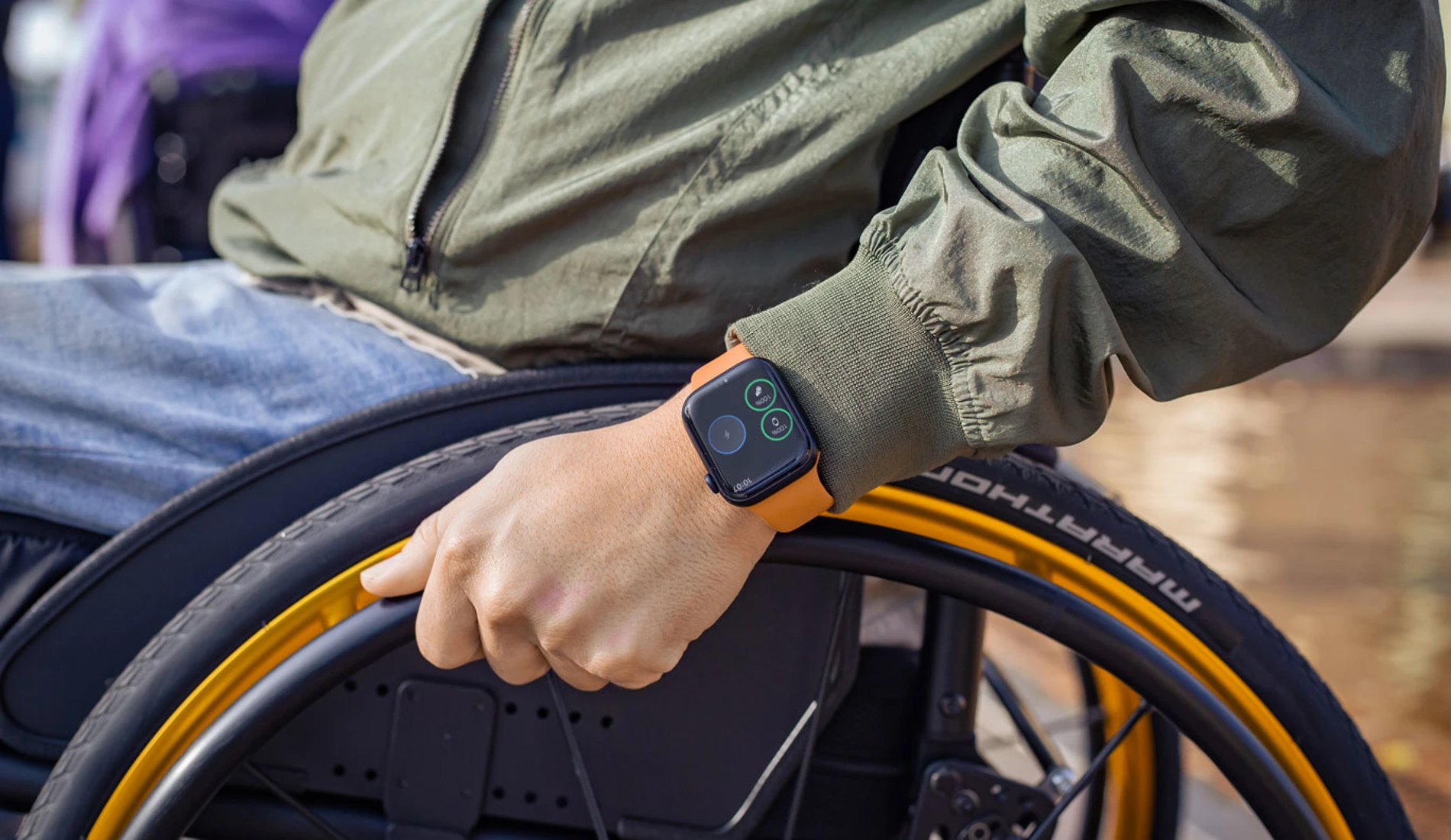 Image of a man wearing his apple watch with a wheelchair banner on the screen.