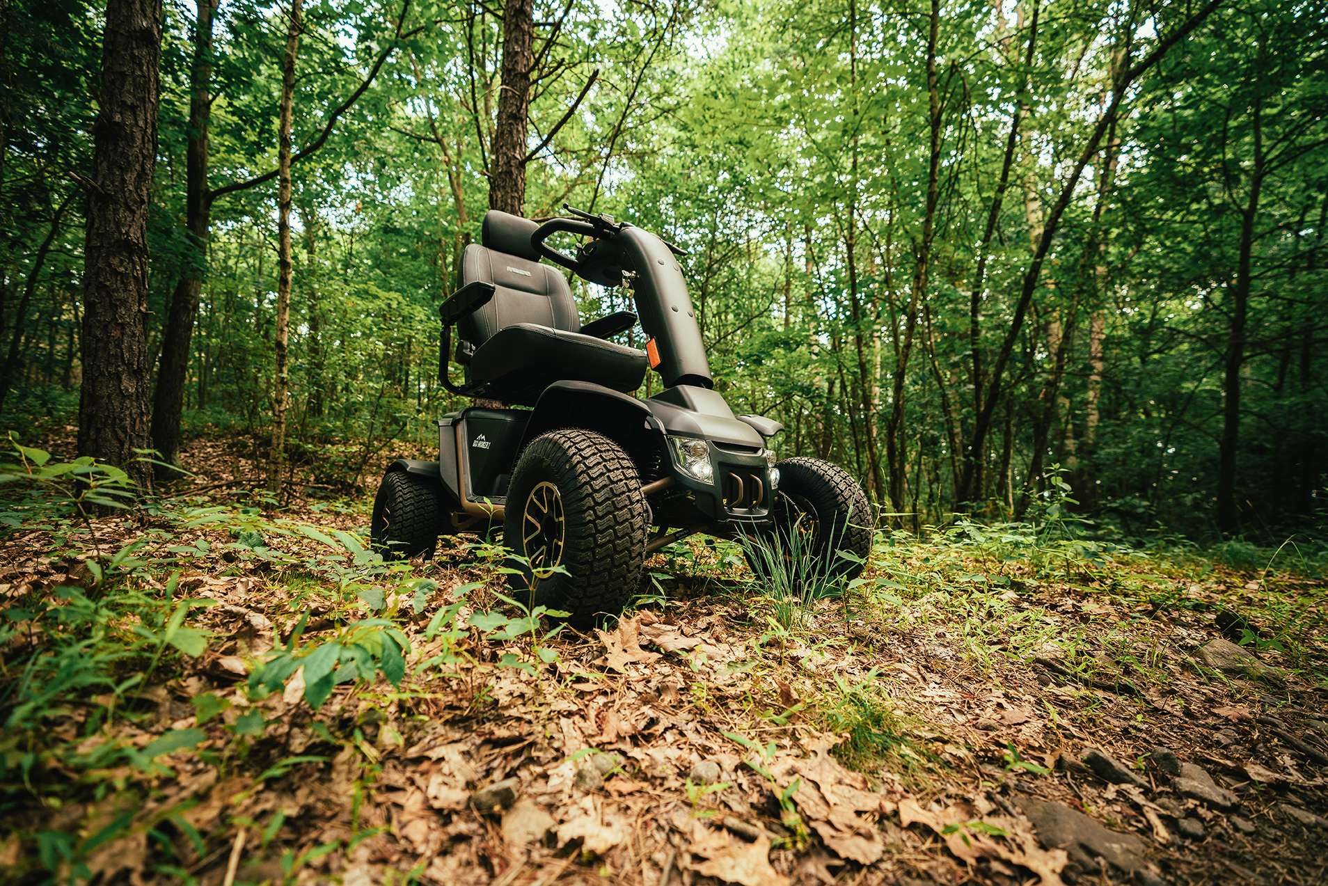 Outdoor image of the Baja Wrangler 2 Powerchair - All-terrain, electric wheelchair designed for outdoor adventures, featuring large knobby tires, suspension, and waterproof components.