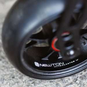 Close up image of the Newton Ultracasters - All-terrain caster wheels for wheelchairs, designed for smooth rolling over various terrains including cobblestones, gravel, and grass.