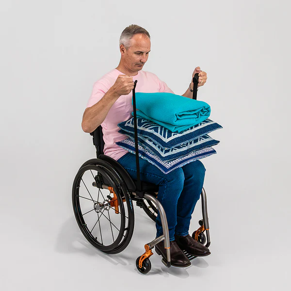 Image of a man utilizing the LapStacker Flex - Retractable carry system for wheelchairs