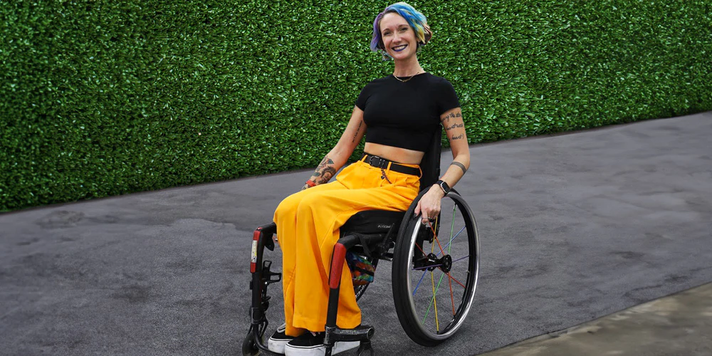 Image of a youthful woman enjoying her Spinergy LX Flexrim Wheelchair Wheel - Lightweight, customizable wheelchair wheel with a urethane pushrim for easier propulsion and a flex design for navigating tight spaces.