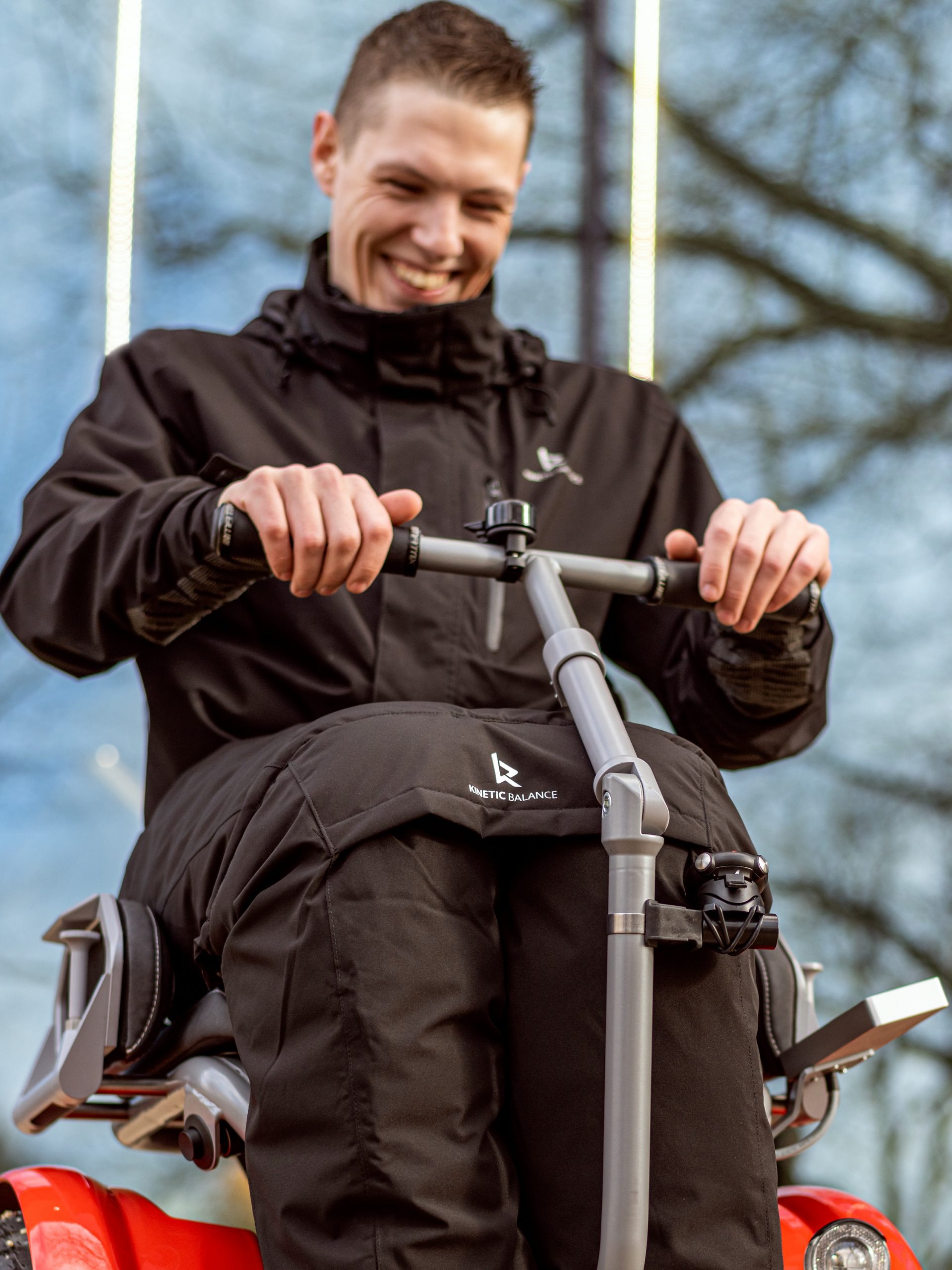 Image of a man enjoying his Kinetic Balance Raindek Raider - Transparent wheelchair cover protecting user from rain and wind.