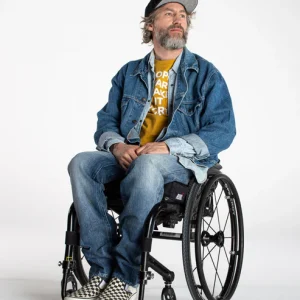 Image of a man sitting in a wheelchair wearing the Kinetic Balance Regular Fit Jeans with Magnetic Closure - Comfortable, dark wash denim jeans featuring a magnetic fly closure for easy dressing, ideal for wheelchair users.