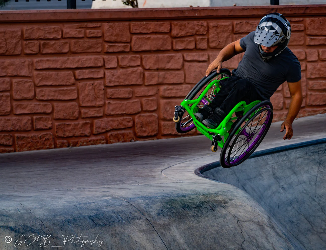 Image of a man at a park utilizing the Spinergy XLX FLEXRIM Wheelchair Wheel - Lightweight, high-performance wheelchair wheel featuring a urethane pushrim for easier propulsion and a flexible design for navigating tight spaces.