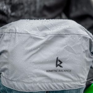 Close up image of the light grey Kinetic Balance RAINDEK Long Wheelchair Cover on a rainy day - Waterproof, transparent cover designed for long-length wheelchairs, offering full protection from rain and wind.